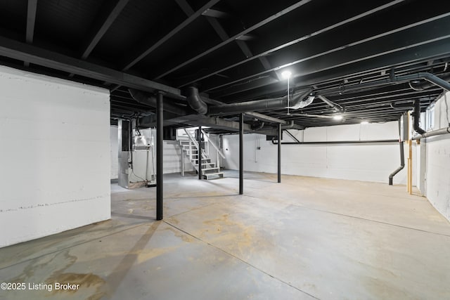 unfinished basement with heating unit and stairs