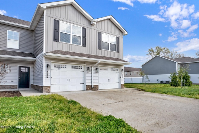 view of front of home featuring board and batten siding, an attached garage, driveway, and a front yard