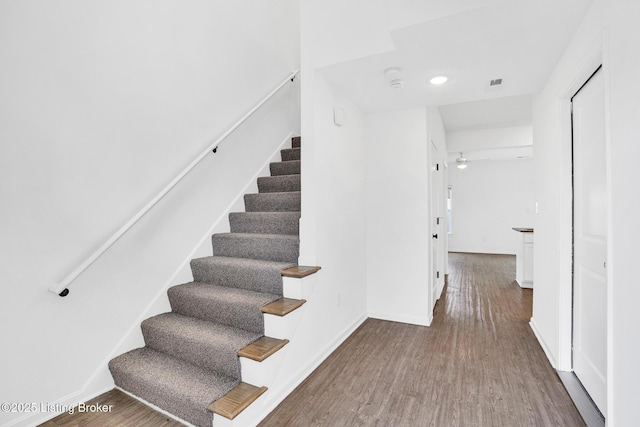 stairs with baseboards, a ceiling fan, wood finished floors, and visible vents