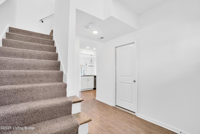 stairs featuring baseboards, recessed lighting, wood finished floors, and visible vents