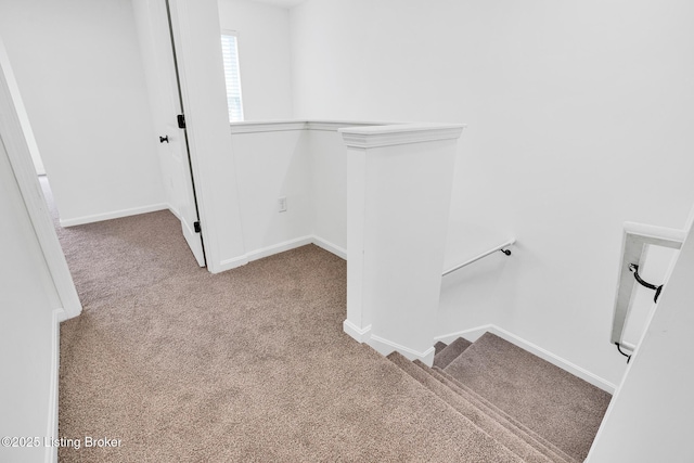 stairway with baseboards and carpet flooring