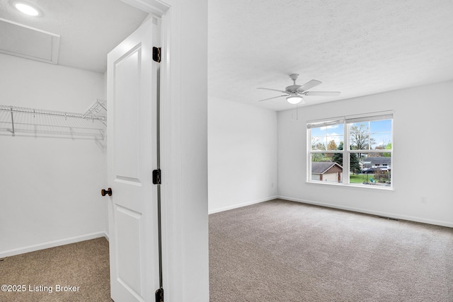 unfurnished bedroom with baseboards, carpet flooring, a textured ceiling, and visible vents