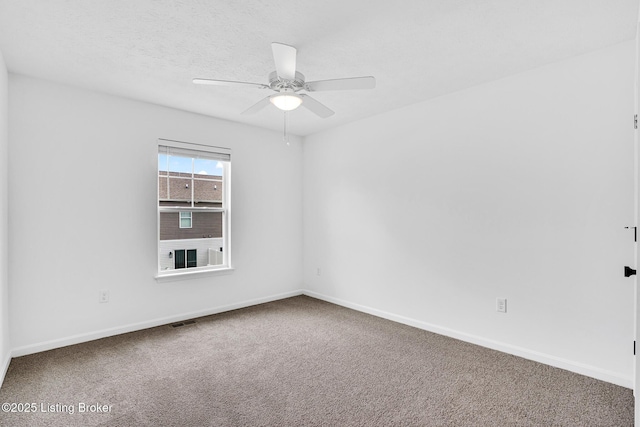 unfurnished room with baseboards, a ceiling fan, carpet flooring, and visible vents