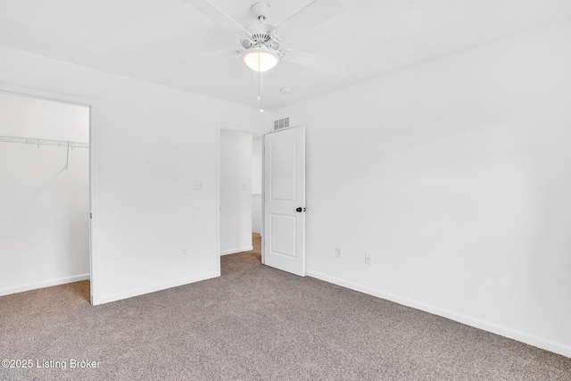unfurnished bedroom featuring carpet floors, baseboards, a closet, and visible vents