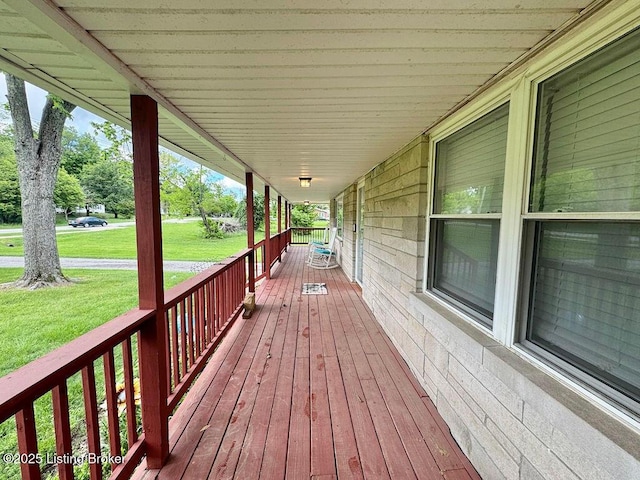 wooden deck with covered porch and a yard