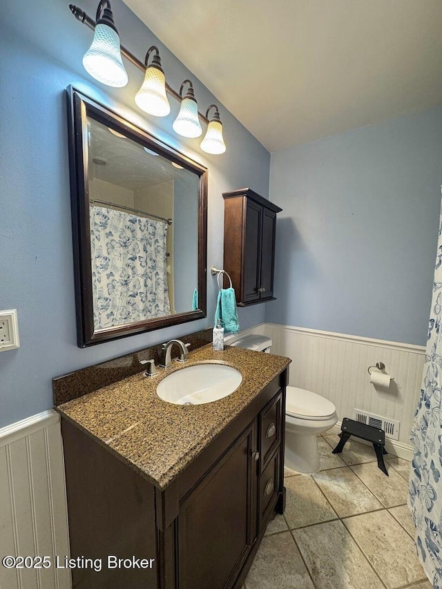 full bath with wainscoting, vanity, and toilet