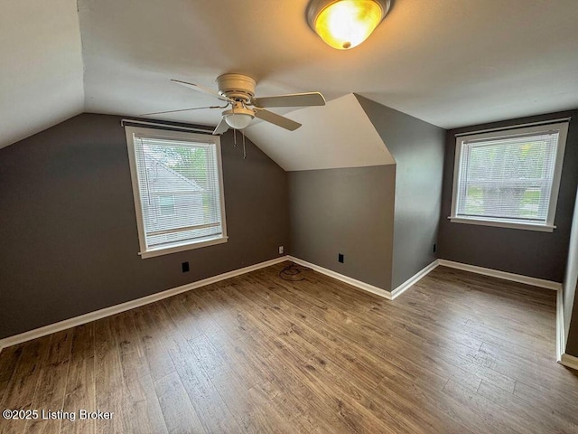 additional living space with a ceiling fan, baseboards, vaulted ceiling, and hardwood / wood-style flooring