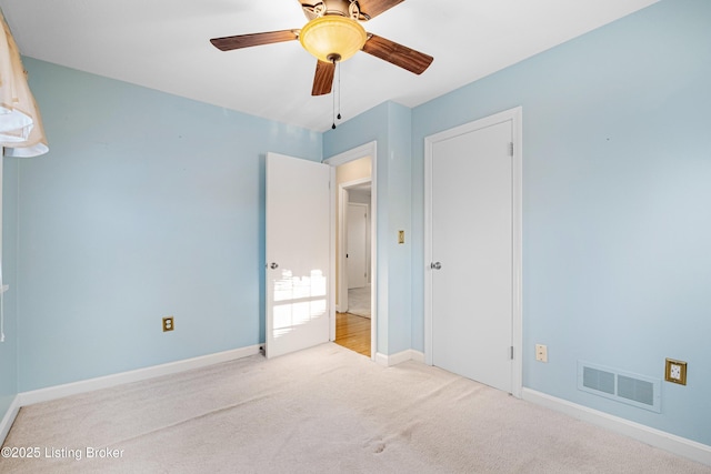 unfurnished bedroom with baseboards, visible vents, ceiling fan, and carpet