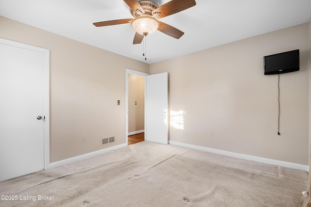 unfurnished bedroom featuring carpet floors, baseboards, ceiling fan, and visible vents