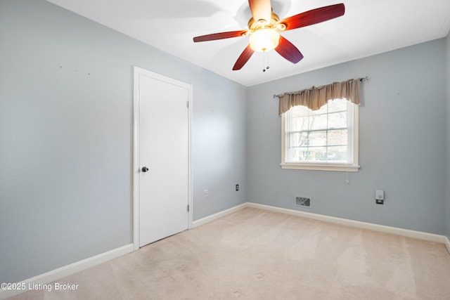 empty room featuring baseboards, a ceiling fan, light colored carpet, and visible vents
