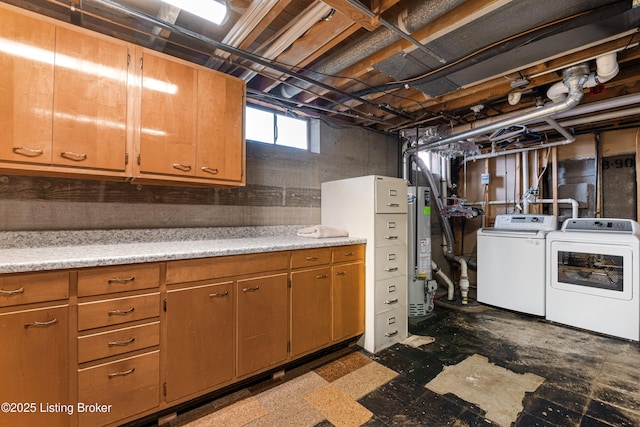 laundry area with independent washer and dryer, water heater, and cabinet space