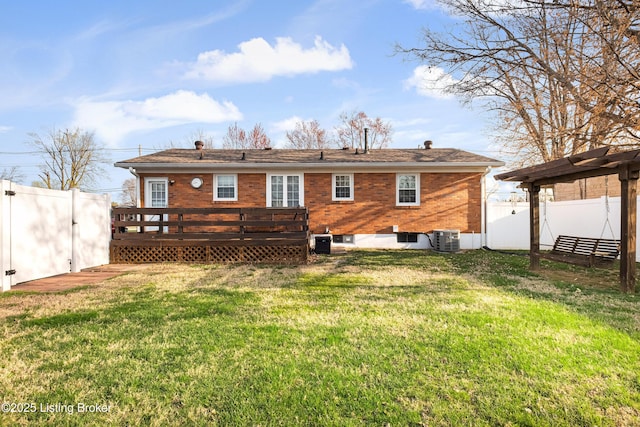rear view of property featuring central AC, a fenced backyard, a lawn, and a wooden deck