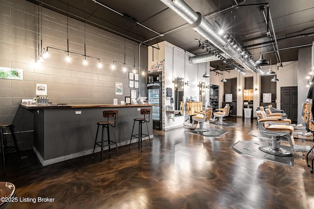 9410 Norton Comnons Blvd, Prospect, KY 40059 - indoor dry bar featuring finished concrete flooring, concrete block wall, and a towering ceiling