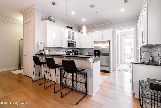 9410 Norton Comnons Blvd, Prospect, KY 40059 - kitchen with stainless steel appliances, dark countertops, crown molding, a peninsula, and backsplash