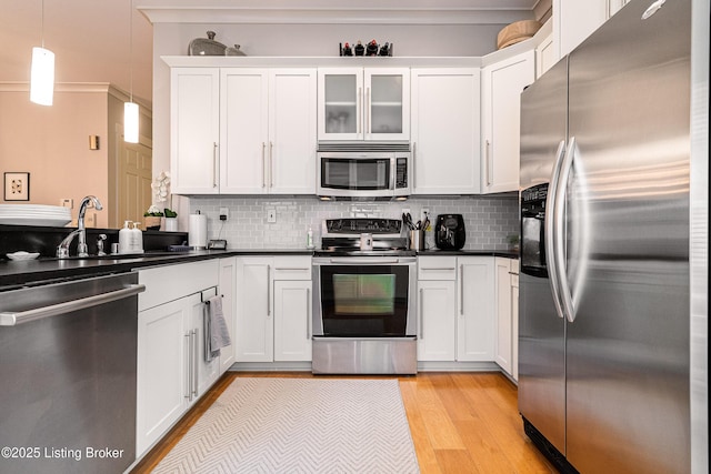 9410 Norton Comnons Blvd, Prospect, KY 40059 - kitchen featuring stainless steel appliances, light wood-type flooring, dark countertops, white cabinetry, and decorative backsplash