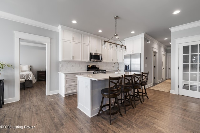 kitchen featuring white cabinets, appliances with stainless steel finishes, ornamental molding, and recessed lighting