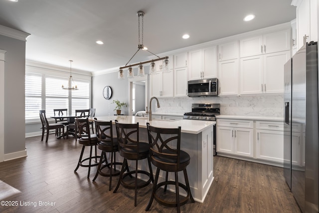 kitchen with stainless steel appliances, white cabinetry, crown molding, light countertops, and tasteful backsplash