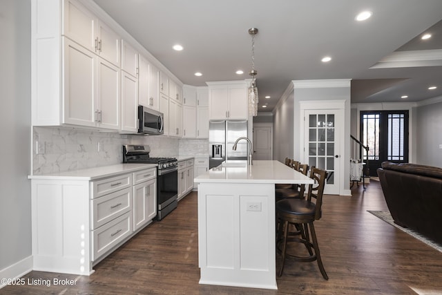 kitchen with ornamental molding, white cabinetry, and appliances with stainless steel finishes