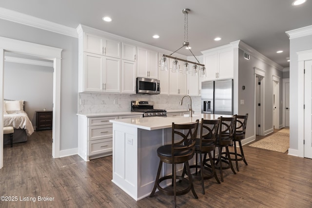 kitchen featuring baseboards, ornamental molding, a sink, stainless steel appliances, and tasteful backsplash