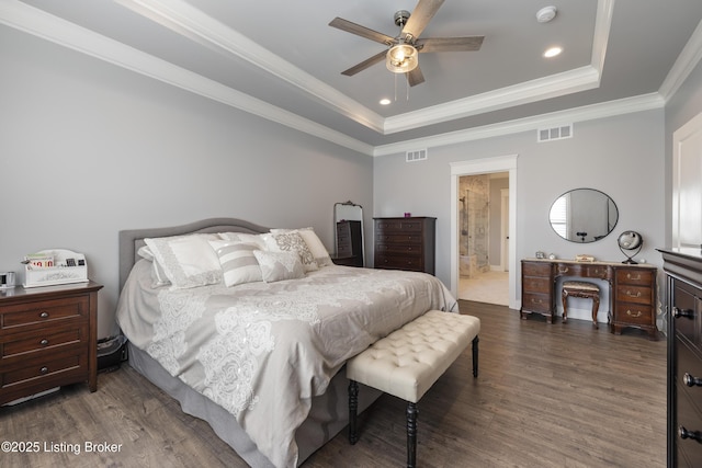 bedroom with a tray ceiling, recessed lighting, visible vents, and wood finished floors