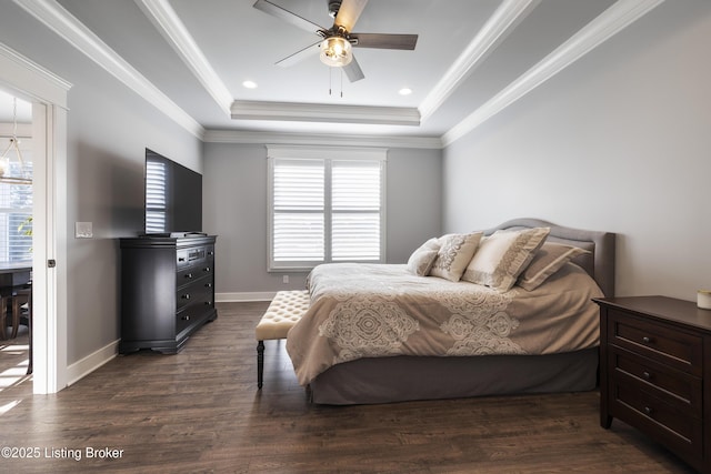 bedroom with multiple windows, dark wood-type flooring, a raised ceiling, and ornamental molding