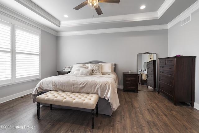 bedroom with a tray ceiling, crown molding, visible vents, and dark wood-type flooring