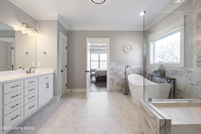 full bath featuring vanity, crown molding, marble finish floor, and a freestanding tub