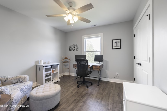 office space with baseboards, ceiling fan, visible vents, and dark wood-style floors