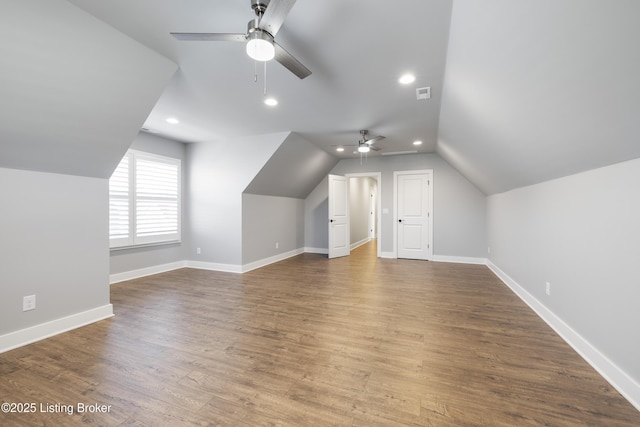 additional living space featuring wood finished floors, visible vents, lofted ceiling, and a ceiling fan