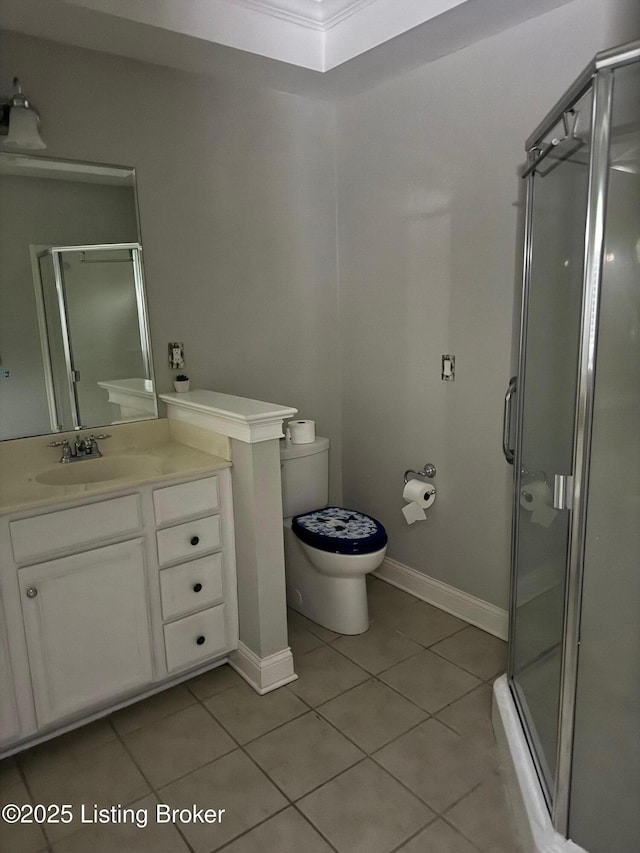 bathroom featuring vanity, toilet, tile patterned flooring, and a stall shower