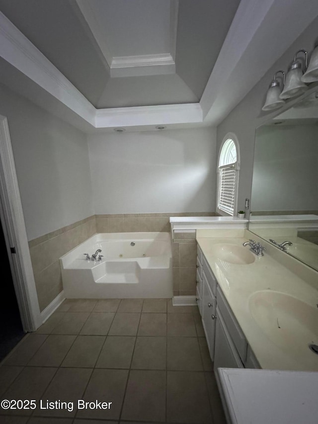 full bath featuring a jetted tub, double vanity, a sink, tile patterned floors, and a raised ceiling