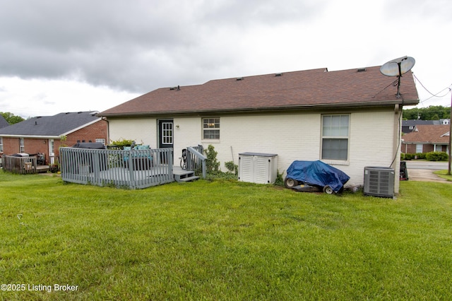 back of house featuring a yard, central air condition unit, a wooden deck, and brick siding