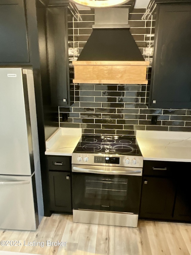 383 Webb Ln, Bedford, KY 40006 - kitchen with electric range, freestanding refrigerator, custom exhaust hood, backsplash, and light wood-style floors
