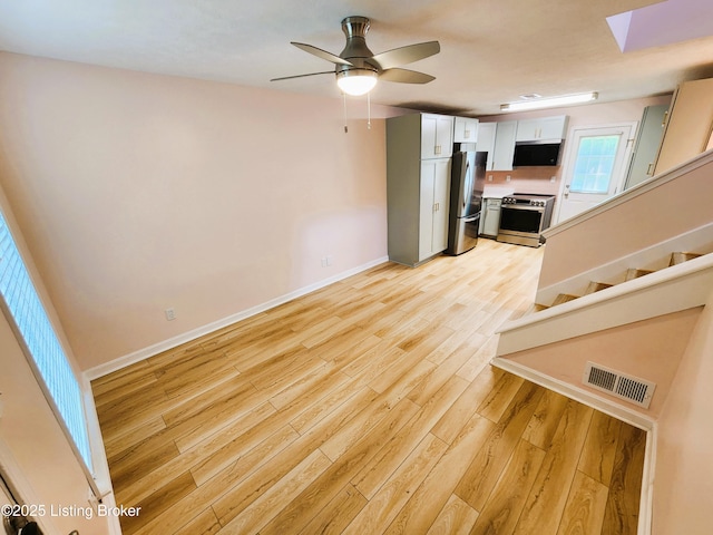 611 Malcolm Ave, Louisville, KY 40223 - unfurnished living room featuring light wood-style flooring, stairs, ceiling fan, and a skylight