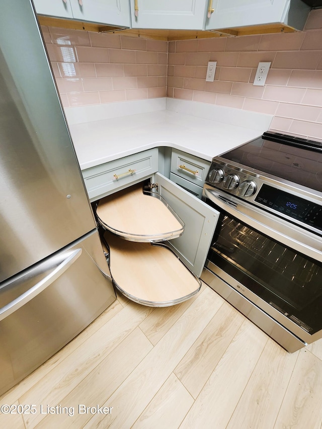 611 Malcolm Ave, Louisville, KY 40223 - kitchen with stainless steel appliances, wood finished floors, light countertops, and tasteful backsplash