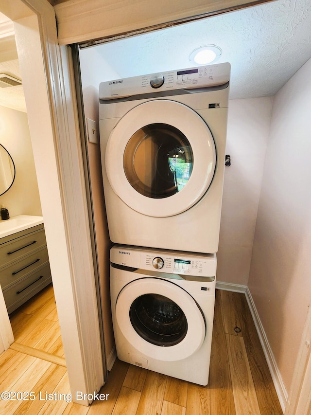 611 Malcolm Ave, Louisville, KY 40223 - washroom featuring stacked washing machine and dryer and wood finished floors