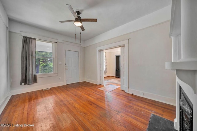 2060 S Preston St, Louisville, KY 40217 - unfurnished living room featuring ceiling fan, baseboards, hardwood / wood-style flooring, and a fireplace