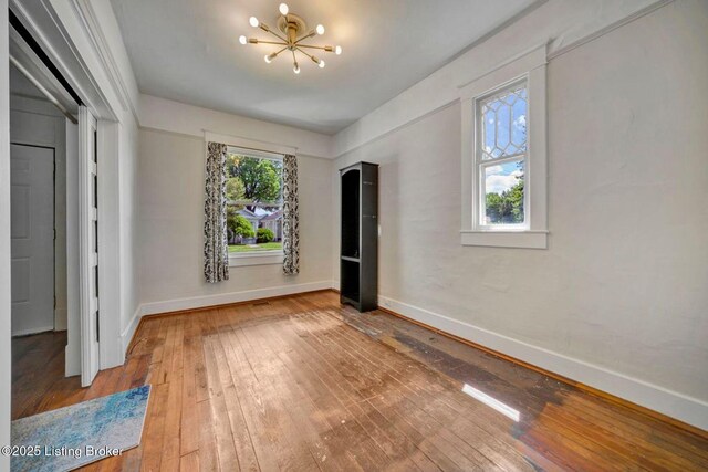 2060 S Preston St, Louisville, KY 40217 - unfurnished bedroom featuring a chandelier, hardwood / wood-style flooring, and baseboards