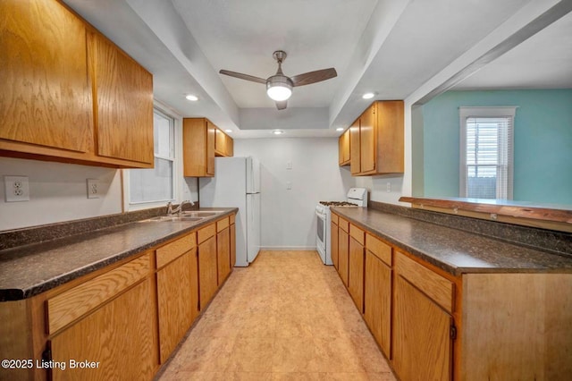 2060 S Preston St, Louisville, KY 40217 - kitchen featuring white appliances, baseboards, dark countertops, a sink, and a ceiling fan