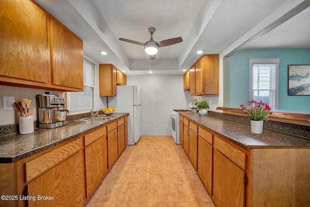 2060 S Preston St, Louisville, KY 40217 - kitchen featuring white appliances, baseboards, a ceiling fan, a raised ceiling, and a peninsula