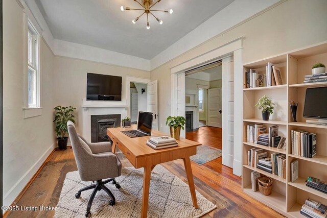 2060 S Preston St, Louisville, KY 40217 - office area featuring a fireplace, wood-type flooring, a chandelier, and baseboards