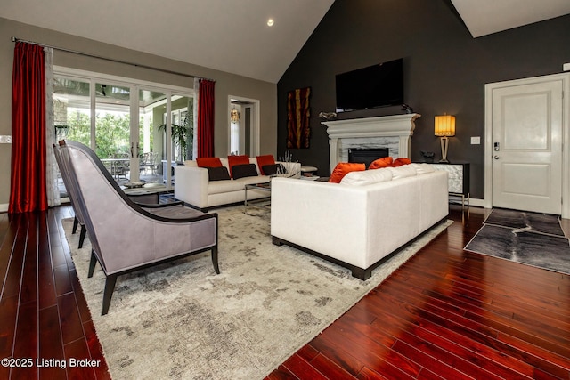 living room featuring hardwood / wood-style flooring, high vaulted ceiling, recessed lighting, a fireplace, and baseboards