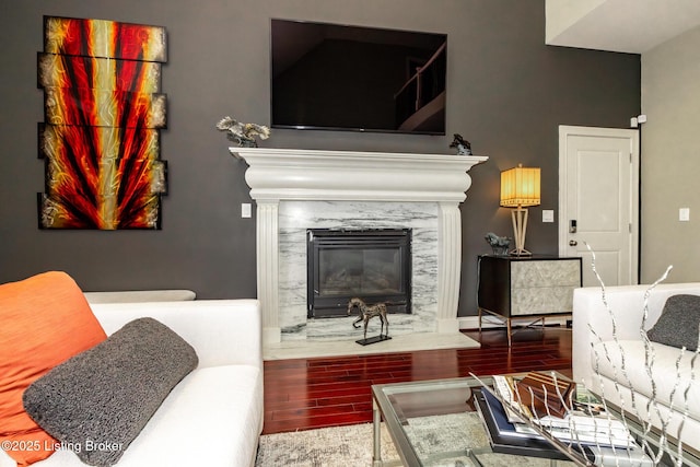 living room with a high end fireplace and wood finish floors