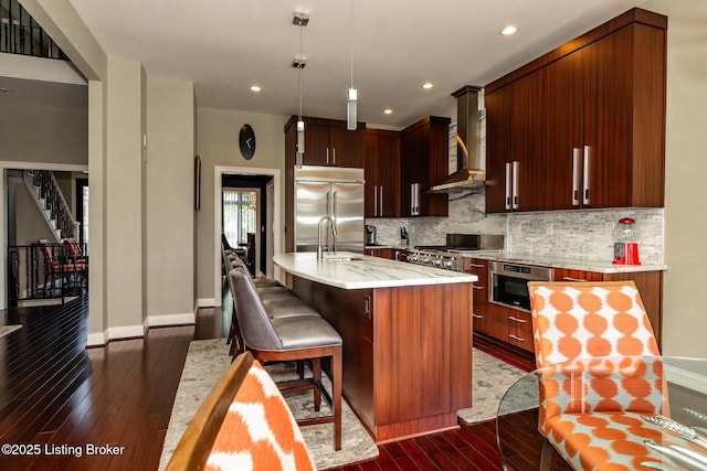 kitchen with baseboards, decorative backsplash, wall chimney exhaust hood, appliances with stainless steel finishes, and dark wood-style floors