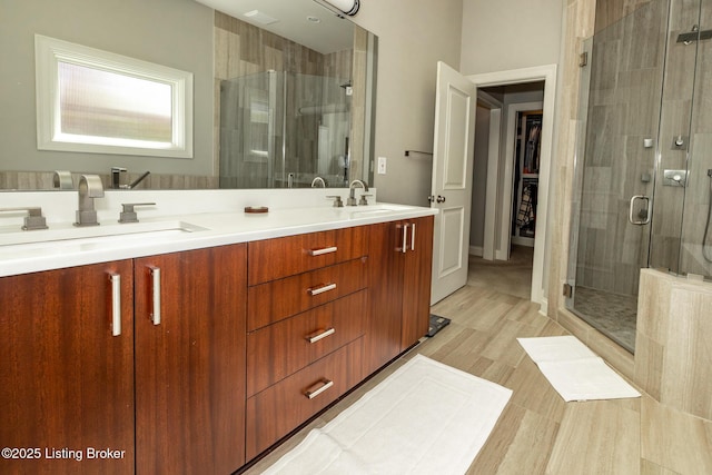 bathroom with a sink, double vanity, and a stall shower