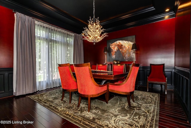 dining area featuring ornamental molding, hardwood / wood-style floors, an inviting chandelier, and a wainscoted wall
