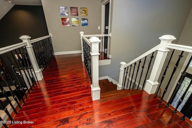 staircase featuring baseboards and wood finished floors