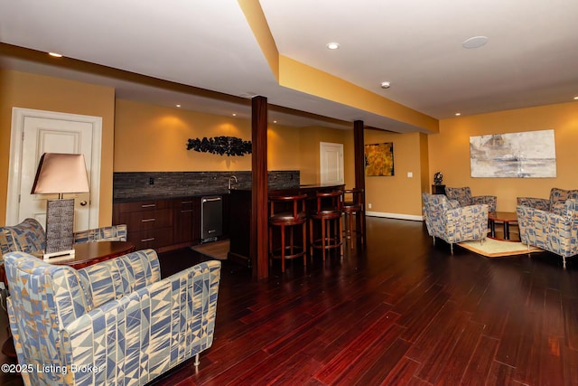 living room with a dry bar, wood finished floors, baseboards, and recessed lighting