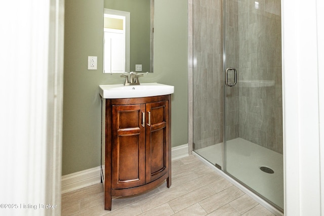 bathroom featuring a shower stall, baseboards, tile patterned floors, and vanity