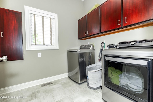 laundry room with cabinet space, independent washer and dryer, visible vents, and baseboards